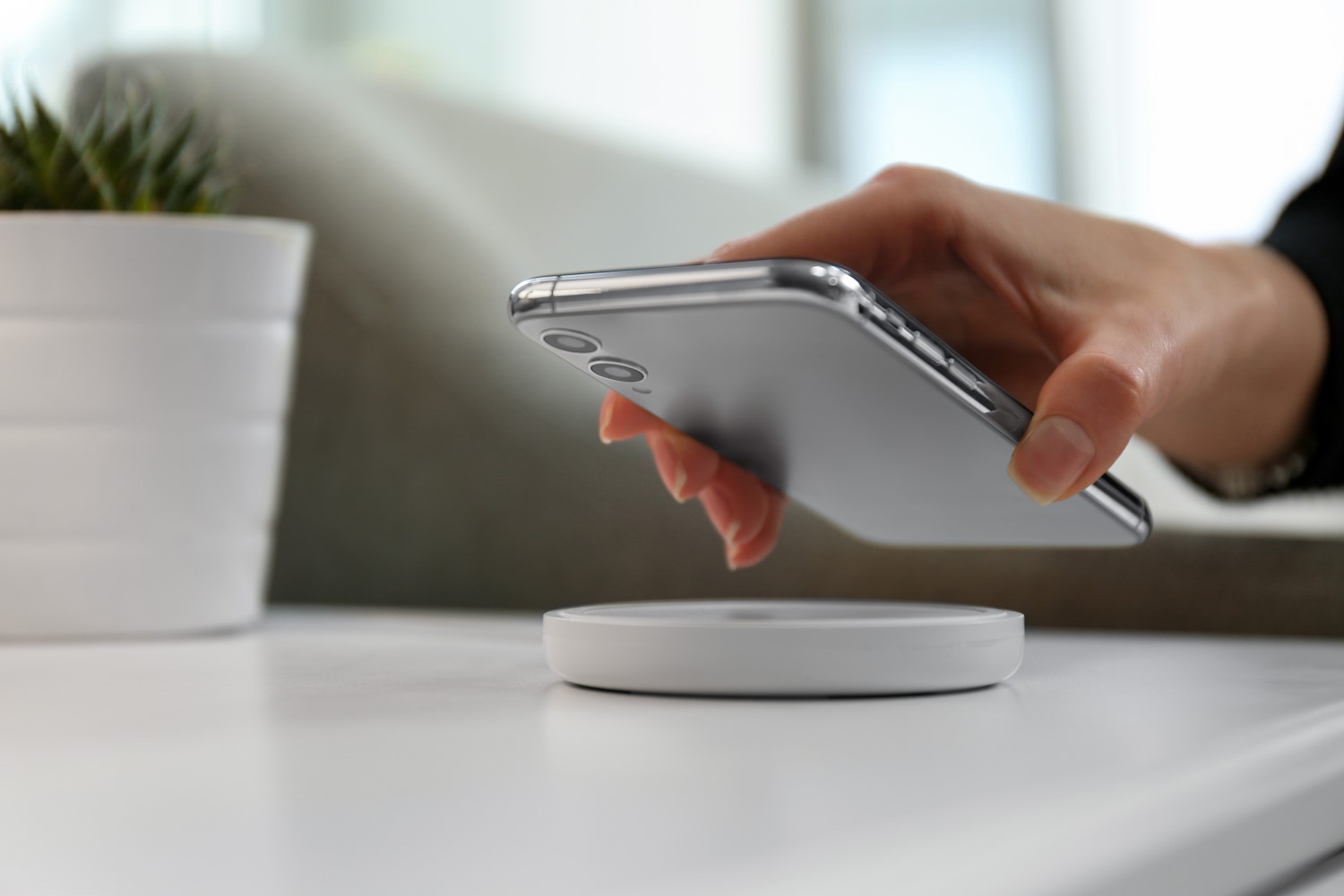 Mujer pone un smartphone a cargar inalámbricamente